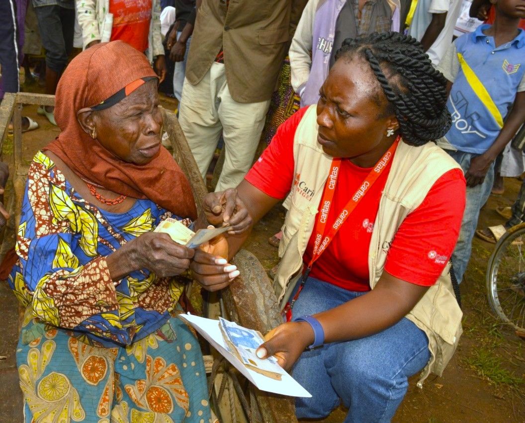 Caritas Nigeria staff hands over cash to an elderly woman during Cash disbursement in Chibok, Borno State
